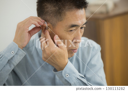 Senior woman wearing a hearing aid Senior woman wearing a hearing aid 130113282