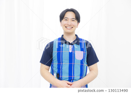 Male nursery teacher wearing an apron Male nursery teacher wearing an apron 130113490