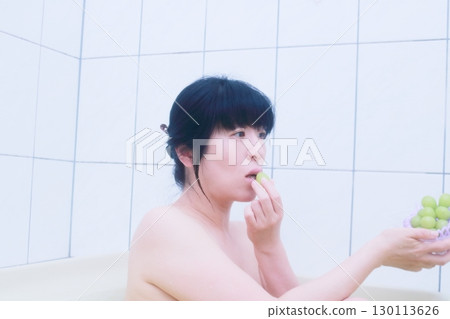 年輕女子在浴缸裡吃葡萄 130113626