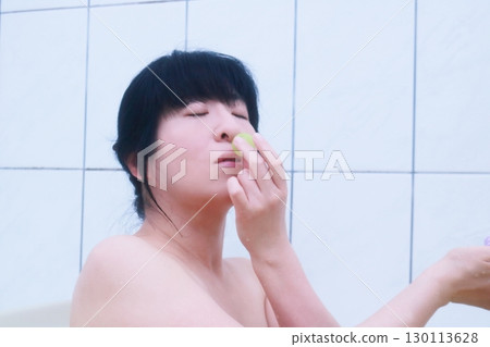 A young woman eating Shine Muscat grapes while taking a bath 130113628