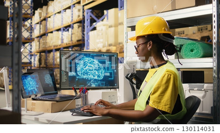 African american woman uses AI deep learning software for e-commerce automation, working in distribution hub with neural networks brain managing tracking software. Data science. Camera A. African american woman uses AI deep learning software for e-commerce automation, working in distribution hub with neural networks brain managing tracking software. Data science. Camera A. 130114031