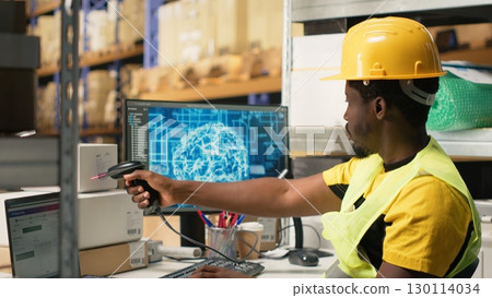 Black worker scanning to register shipping labels tracking info with AI brain, package tracking software helps handling online shopping orders with neural networks automation. Camera B. 130114034