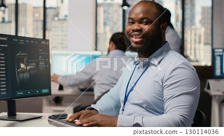 Engineer improves wind turbine carbon footprint by optimizing blade aerodynamics. RD department worker testing advanced materials of eco friendly windmill in office, camera B 130114036