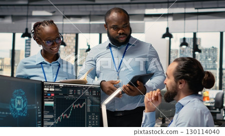 Teamworking traders in prop firm office leverage AI tech to interpret charts, optimizing buying and selling. Brokerage coworkers doing brainstorming, using deep learning to maximize profits 130114040