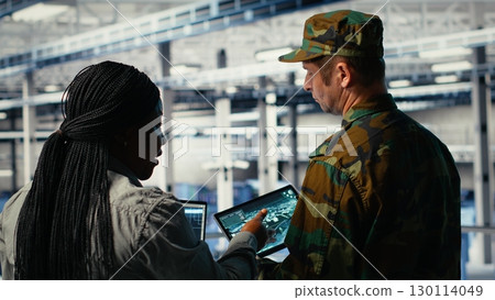 Military data center engineers using AI machine learning radar software to watch for enemy threats. Army technicians in data center use artificial intelligence on devices to detect dangers, camera B Military data center engineers using AI machine learning radar software to watch for enemy threats. Army technicians in data center use artificial intelligence on devices to detect dangers, camera B 130114049