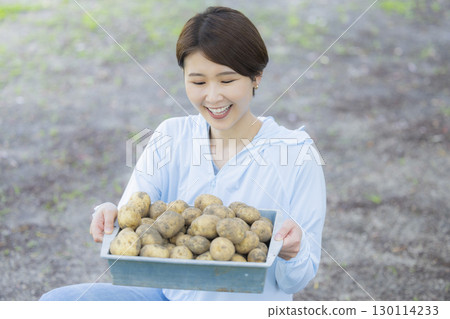 Woman holding harvested potatoes Woman holding harvested potatoes 130114233