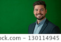 A friendly face with an engaging smile dressed in business casual attire framed by a green background 130114945