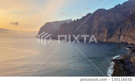 The breathtaking scenic coastal cliffs appear mesmerizing at sunset above the calm waters 130116038