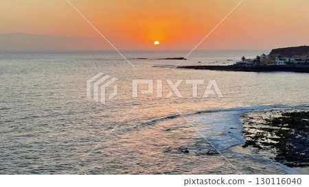 Experience the breathtaking sunset over tranquil coastal waters, a sight that captivates all 130116040