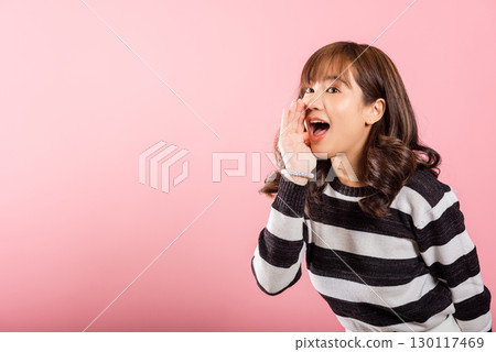 Asian happy portrait beautiful cute young woman teen standing hand on mouth talking news announcement studio shot isolated on pink background, Thai female shout out announcement Asian happy portrait beautiful cute young woman teen standing hand on mouth talking news announcement studio shot isolated on pink background, Thai female shout out announcement 130117469