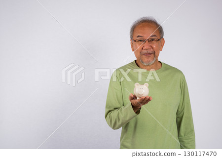 Portrait smiling Asian older man holding white piggy bank on hand studio shot isolated on white background, Concept of responsibility and financial planning, Saving money after retirement Portrait smiling Asian older man holding white piggy bank on hand studio shot isolated on white background, Concept of responsibility and financial planning, Saving money after retirement 130117470