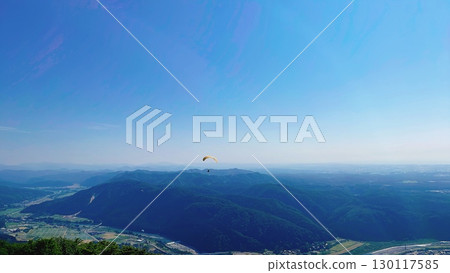 Watching paragliders from a plateau under the blue sky 130117585