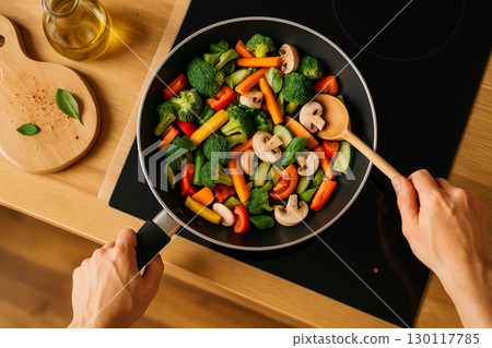 AI generated overhead view of fresh mixed vegetables being stir fried in a black pan with vibrant colors symbolizing healthy lifestyle freshness and simple home cooking 130117785
