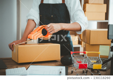 Online small business owner is packing products for customers according to their orders online-Shopping online concept. Online small business owner is packing products for customers according to their orders online-Shopping online concept. 130118260