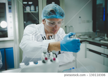 Scientist using pipette in modern laboratory with microscope for medical biology and chemistry research experiment study Scientist using pipette in modern laboratory with microscope for medical biology and chemistry research experiment study 130118306