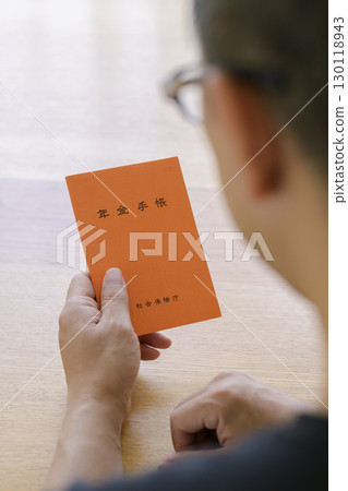 A man looking at his pension book 130118943