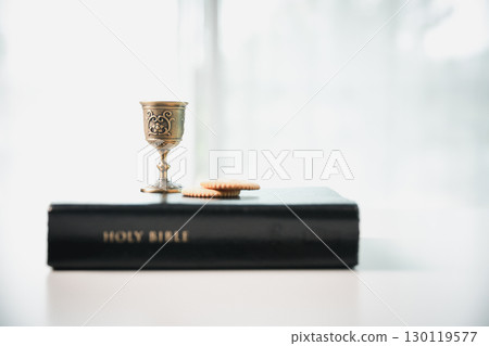 Christianity, holy communion ceremony is sacred act of worship and faith, where bread and wine in chalice symbolize body and blood of Christ in the religious eucharist tradition. 130119577