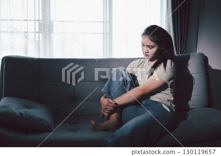 Depression woman sit on sofa. Despair sorrow person sitting alone and hugging knees, Boring sad upset frustrated stressed. struggling to find hope amid suffocating burden. mental health concept. 130119657