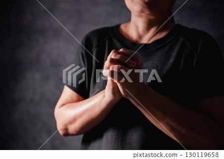 Christian woman lifts her hand in worship to pray, hope, faith, and deep belief in God defines core concept of religion. Praying hands with faith in religion, belief in God. Power of hope or love. 130119658