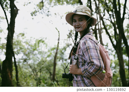 Young female traveler with backpack walking in national park or forest. recreation sport in nature. Female person bag, wave for hiking journey in woods. adventure in forest. trekking with backpack Young female traveler with backpack walking in national park or forest. recreation sport in nature. Female person bag, wave for hiking journey in woods. adventure in forest. trekking with backpack 130119892