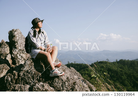 Woman hiker on top of mountain. Hiker with arms up on top of mountain successful young woman enjoying triumph. traveler exploring world. Hikers with backpacks relaxing. Sport and success concept. 130119964