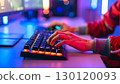 Close-up of hands operating the illuminated keyboard on a gaming PC 130120093