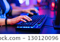 Hands typing on a gaming keyboard with RGB lighting 130120096