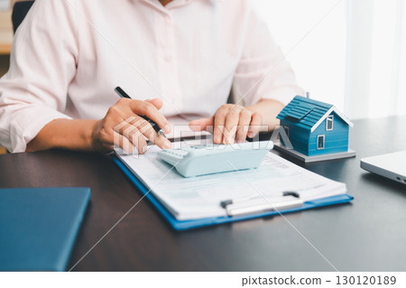 Calculator to check and summary expense of home loan mortgage for refinance plan , people lifestyle concept. Home agents are using calculator to calculate the loan period each month for customer. Calculator to check and summary expense of home loan mortgage for refinance plan , people lifestyle concept. Home agents are using calculator to calculate the loan period each month for customer. 130120189