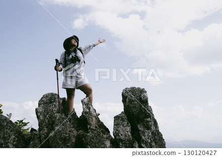 Woman hiker on top of mountain. Hiker with arms up on top of mountain successful young woman enjoying triumph. traveler exploring world. Hikers with backpacks relaxing. Sport and success concept. 130120427