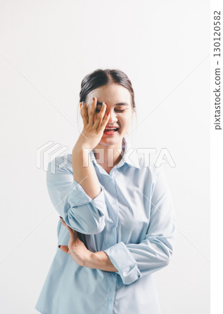 Asian woman rejoicing, looking happy, champion, fist pump gesture, standing over white background. young woman had happy, positive expression on her face, highlighted by bright smile. 130120582