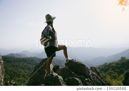 Woman hiker on top of mountain. Hiker with arms up on top of mountain successful young woman enjoying triumph. traveler exploring world. Hikers with backpacks relaxing. Sport and success concept. Woman hiker on top of mountain. Hiker with arms up on top of mountain successful young woman enjoying triumph. traveler exploring world. Hikers with backpacks relaxing. Sport and success concept. 130120588