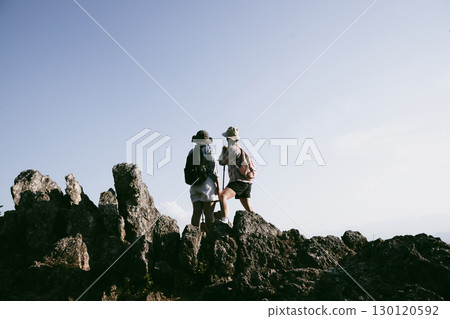 Woman hiker on top of mountain. Hiker with arms up on top of mountain successful young woman enjoying triumph. traveler exploring world. Hikers with backpacks relaxing. Sport and success concept. Woman hiker on top of mountain. Hiker with arms up on top of mountain successful young woman enjoying triumph. traveler exploring world. Hikers with backpacks relaxing. Sport and success concept. 130120592