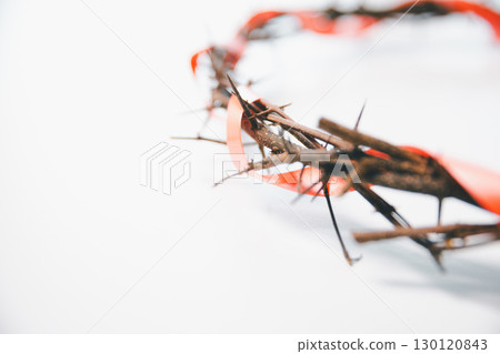 Crown of thorns on white table background. Easter, central celebration in Christianity, honors sacrifice of Jesus Christ, crown of thorns symbolizes redemption, faith, deep spirituality of religion. 130120843