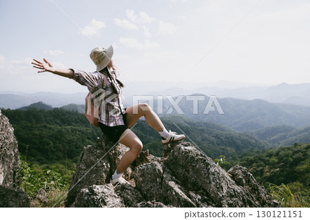 Woman hiker on top of mountain. Hiker with arms up on top of mountain successful young woman enjoying triumph. traveler exploring world. Hikers with backpacks relaxing. Sport and success concept. 130121151