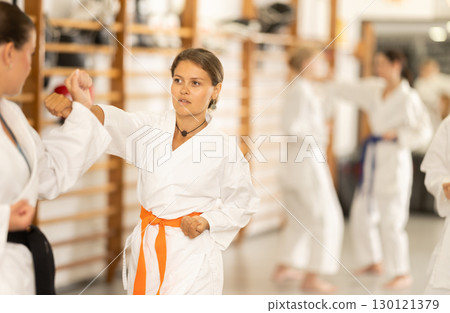 Women in kimono exercising in pairs during training 130121379