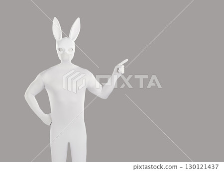 Man in white bodysuit and rabbit mask pointing to side on grey copy space background Man in white bodysuit and rabbit mask pointing to side on grey copy space background 130121437