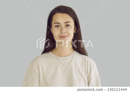 Headshot of a smiling confident calm caucasian young brunette woman girl looking at camera. 130121444