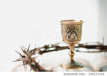 Christianity, holy communion ceremony is sacred act of worship and faith, where bread and wine in chalice symbolize body and blood of Christ in the religious eucharist tradition. 130121542