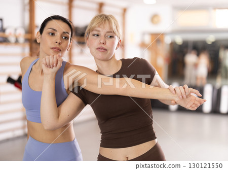 Purposeful engrossed women train during self-defense fight training session in gym 130121550