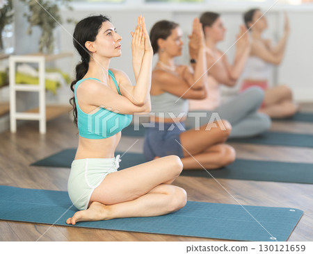Group of women of working out practice Lord of fishes pose Group of women of working out practice Lord of fishes pose 130121659