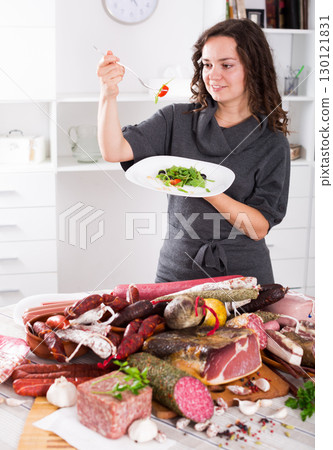 Girl prefers to eat greens, but not sausages Girl prefers to eat greens, but not sausages 130121831