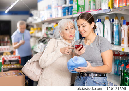 Woman purchasers choosing liquid detergent in big supermarket 130121896