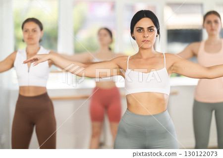 Young ballerinas rehearse ballet poses during ballet classes 130122073