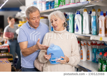 Man and woman purchasers choosing liquid detergent in big supermarket 130122088