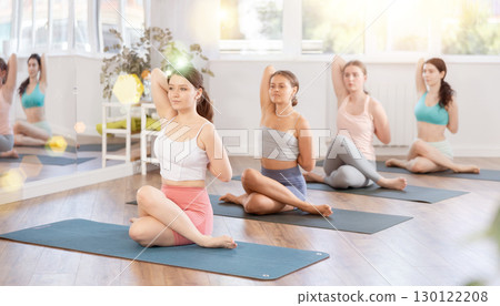 Group of women of working out practice Lord of fishes pose 130122208
