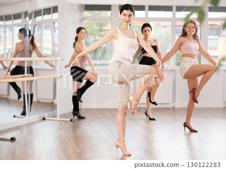 During lesson, girl learn to move and perform dance in heels with women companions 130122283