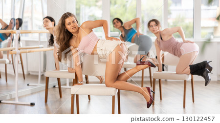 Slender women rehearse modern dances using chair Slender women rehearse modern dances using chair 130122457