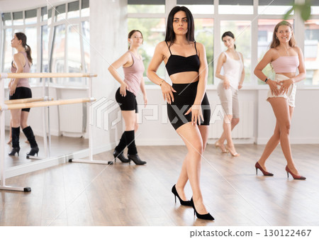 During lesson, girl learn to move and perform dance in heels with women companions 130122467