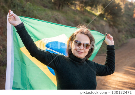 Smiling woman holding large flag of Brazil 130122471