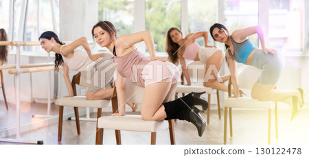 Slender women rehearse modern dances using chair 130122478